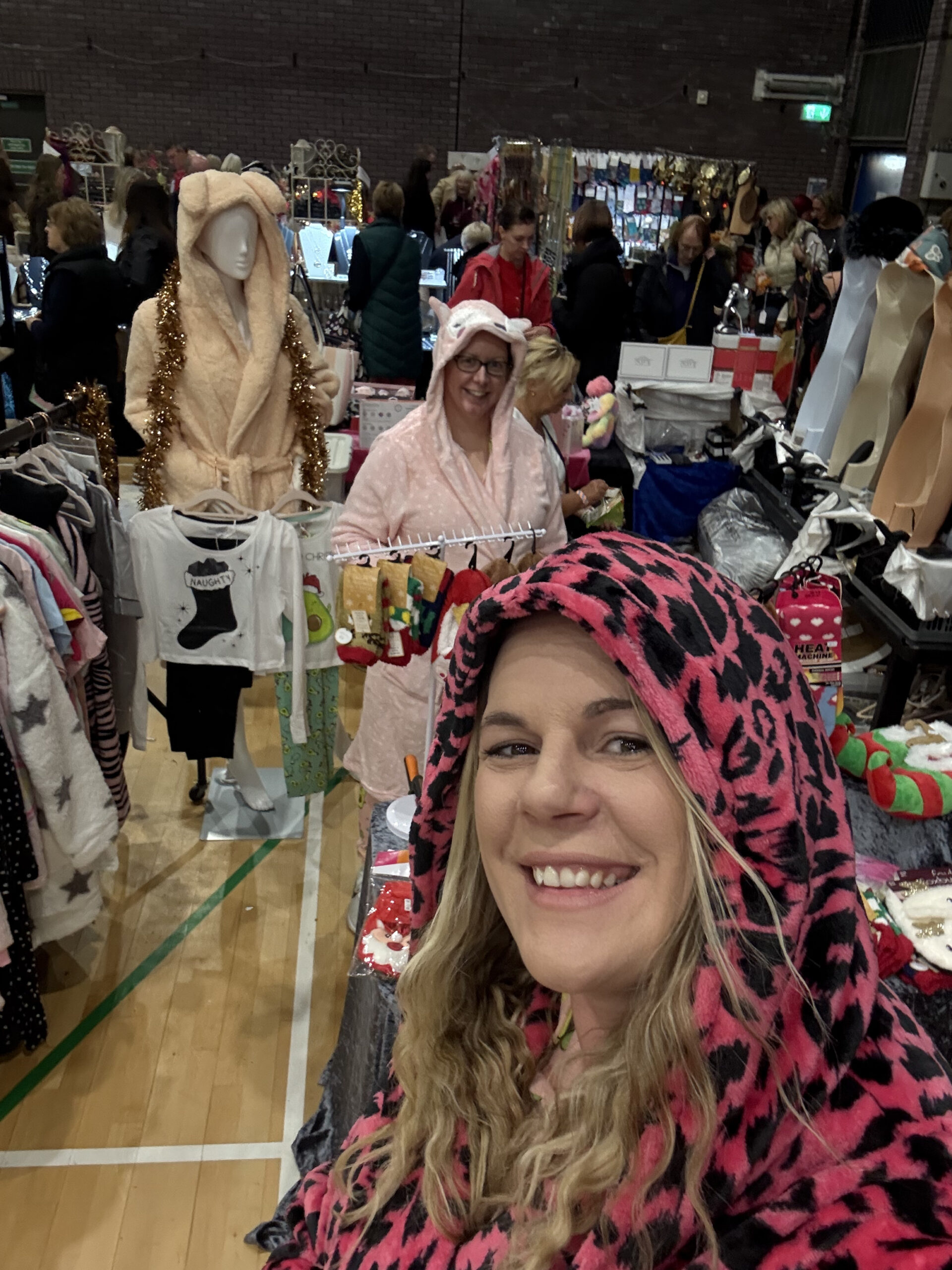 Woman wearing a cosy women’s hooded dressing gown at home, relaxing on a sofa.